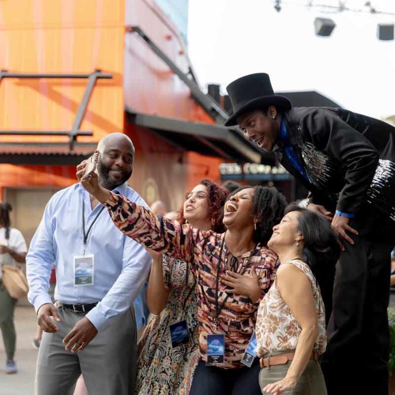 Event attendees taking a selfie with a stiltwalker at a CityWalk Block Party event.