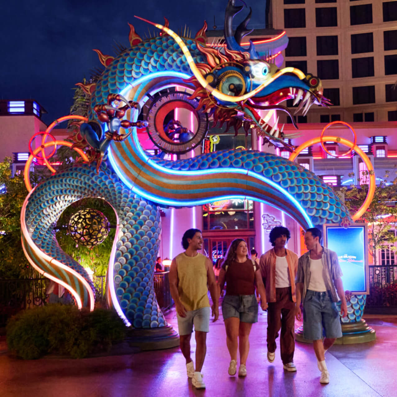Illuminated dragon sculpture with guests walking through Celestial Park at night at Universal Epic Universe.