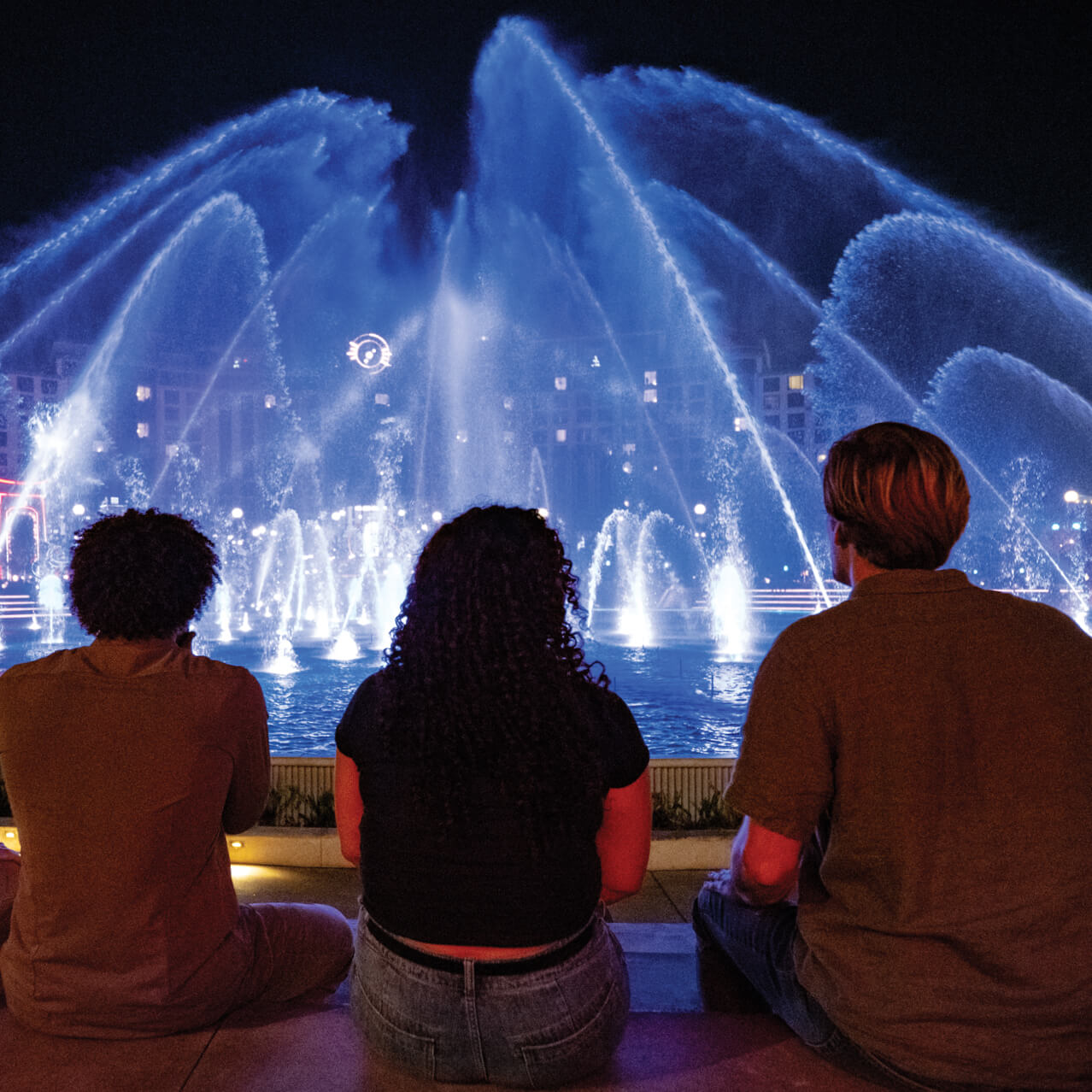Guests watch illuminated fountains during the nighttime show in Celestial Park at Universal Epic Universe.