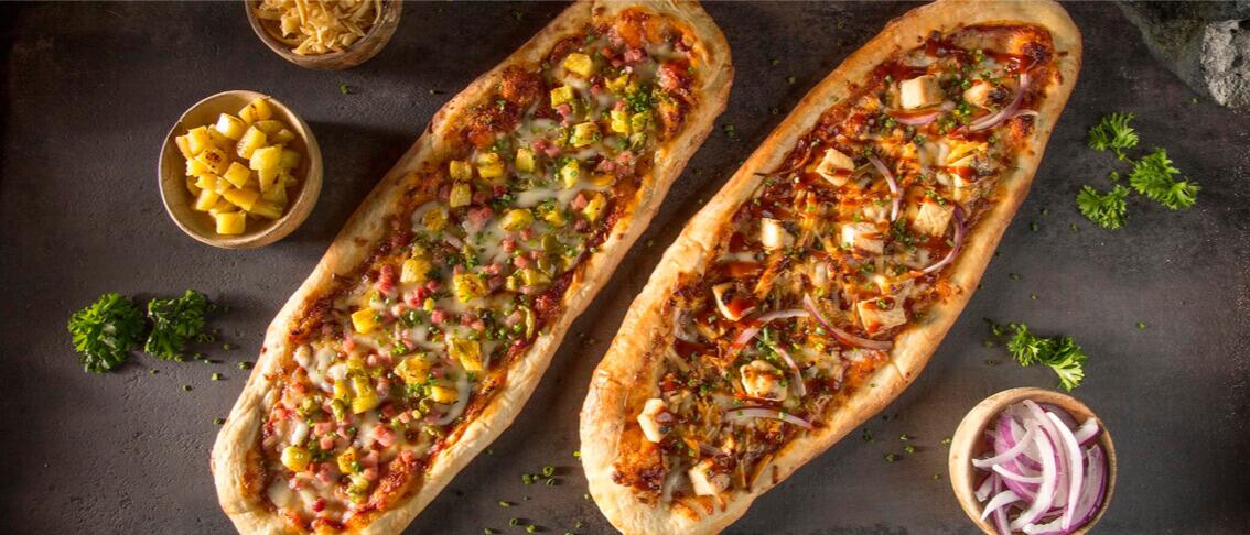 Table view of two delectable pizzas at the Bambu Restaurant at Universal Volcano Bay