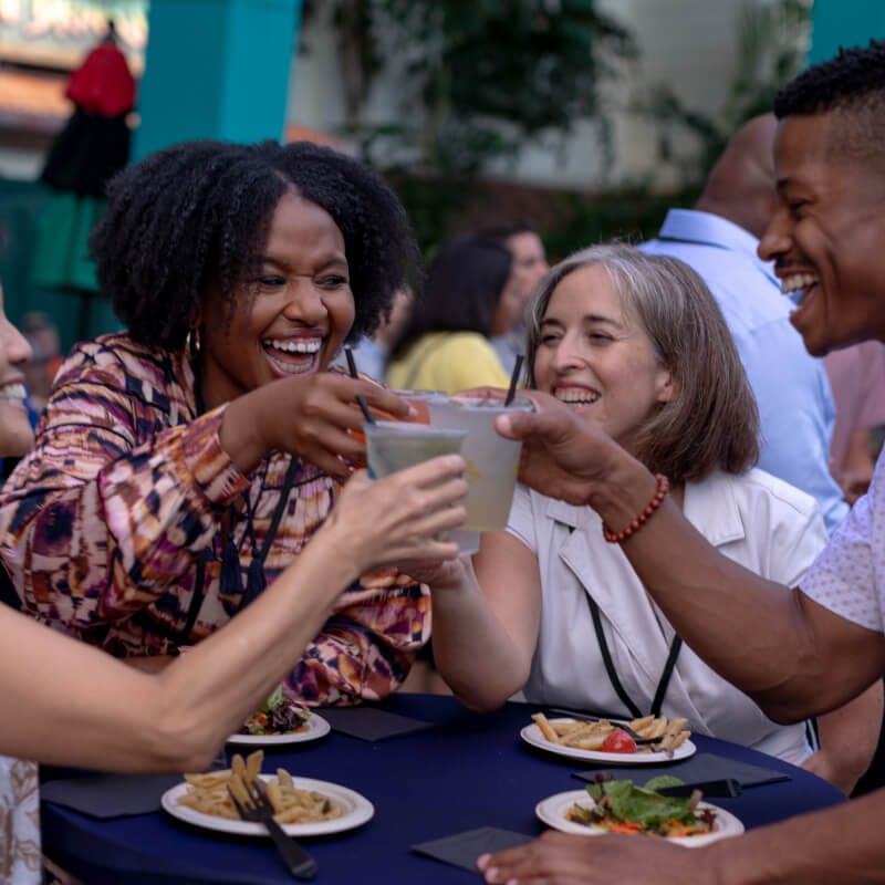 Event attendees laughing and enjoying food and beverages at a CityWalk Block Party event.