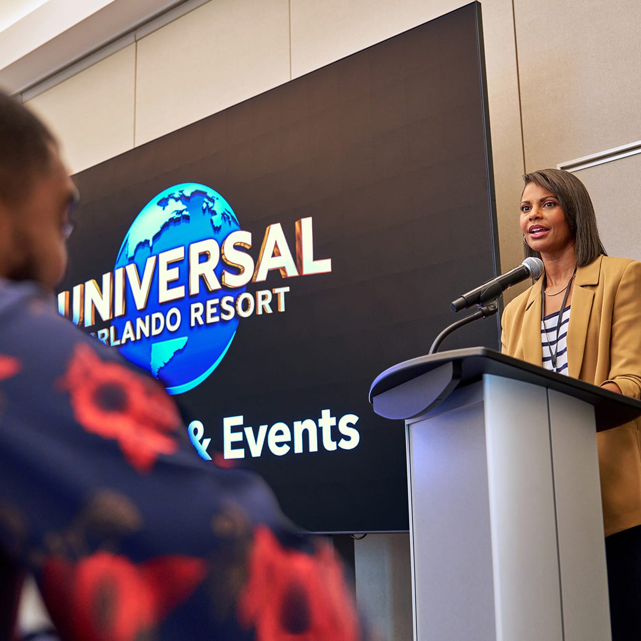 A speaker leads a presentation in the Grand Hall at Universal Helios Grand Hotel.