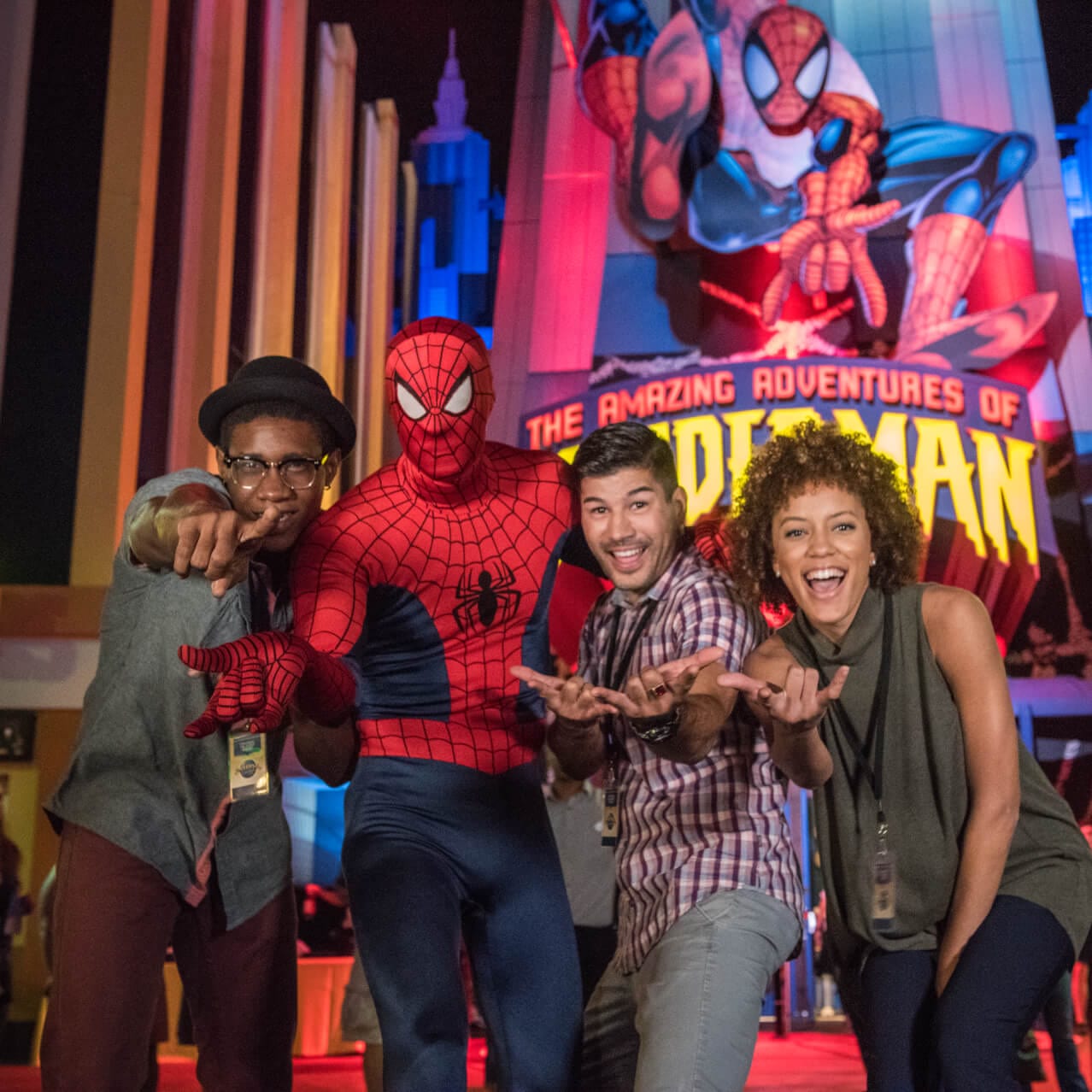 Smiling guests posing with Spider-Man outside of the Amazing Adventures of Spider-Man event