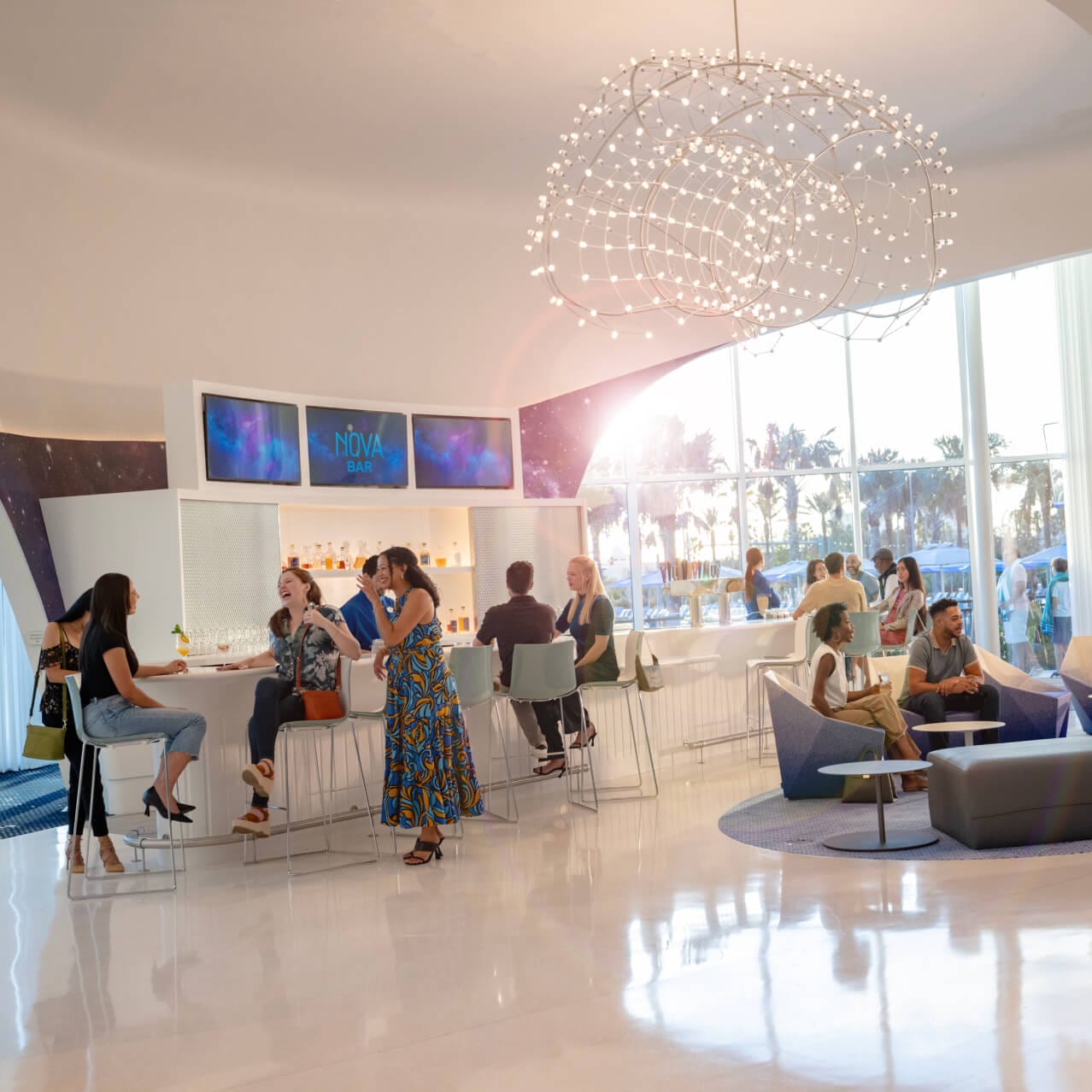 Guests enjoying conversation at Nova Bar, located inside Universal Stella Nova Resort.