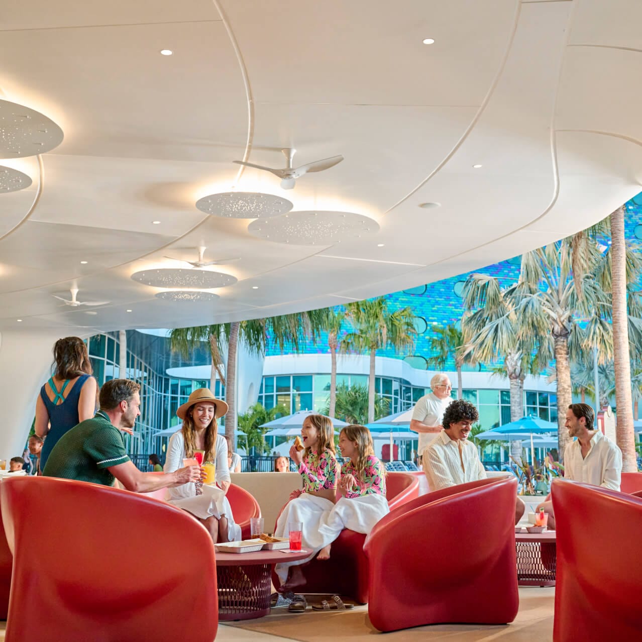 A young family sits around a table sharing a meal in the open-air Moonrise Bar at Universal Terra Luna Resort.