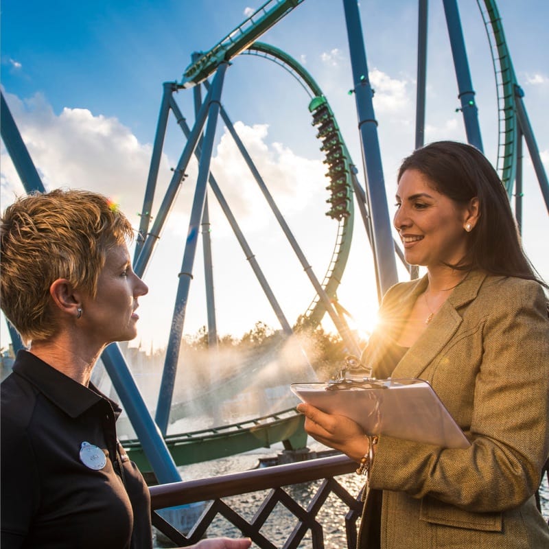 Two women having a meeting at Universal Orlando with a roller coaster in the background