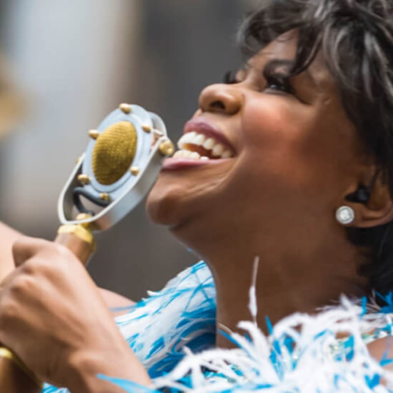 Celestina Warbeck sings holding a microphone