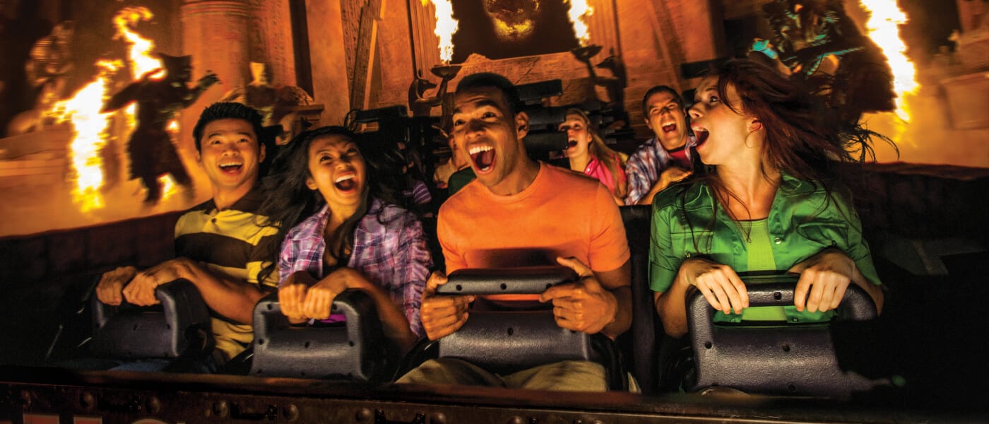 Four astonished guests ride in the front row seat of a Revenge of the Mummy ride