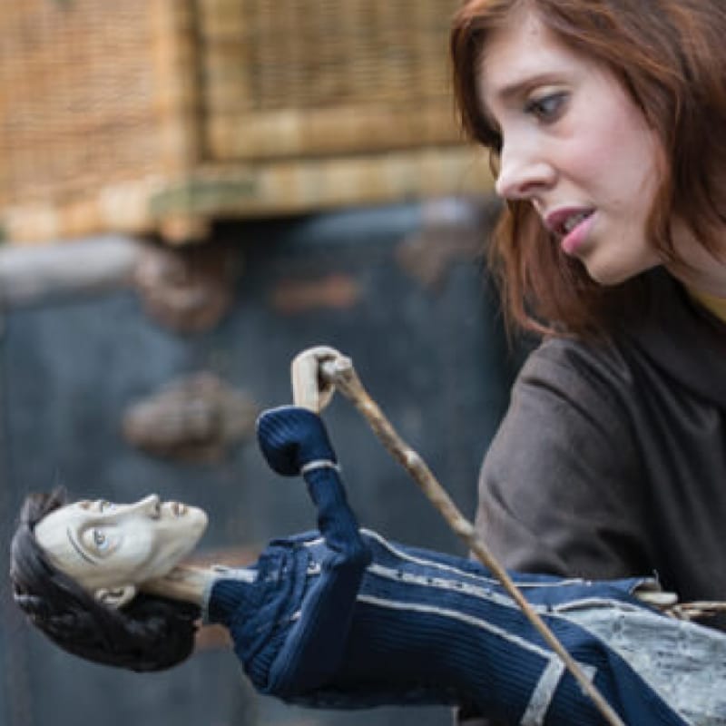 woman looks endearingly at a puppet