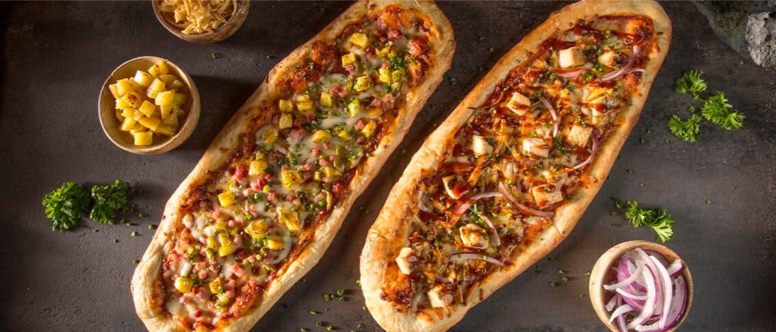 Table view of two delectable pizzas at the Bambu Restaurant at Universal Volcano Bay