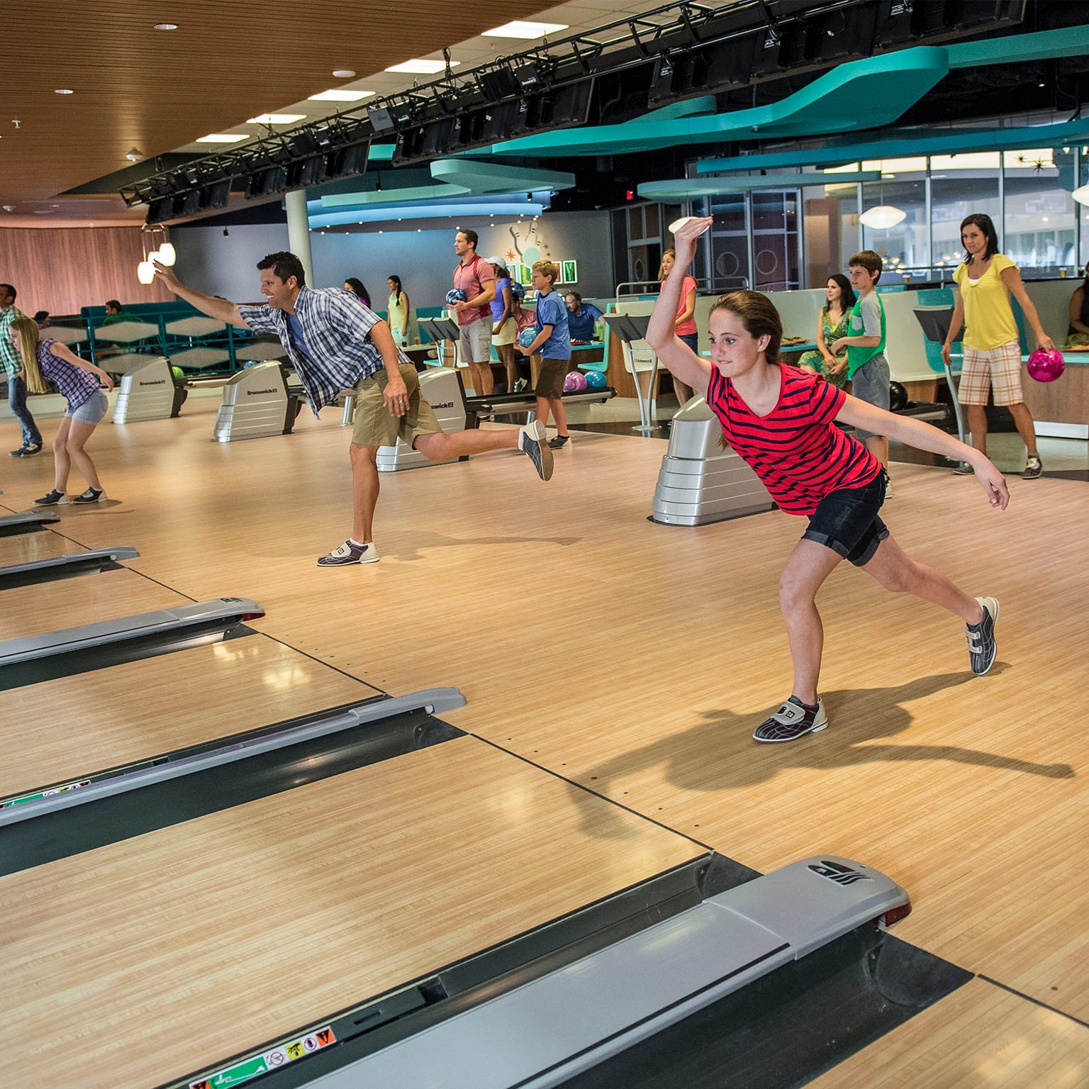 A girl throws a bowling ball down the lane at Galaxy Bowl, a fun, retro bowling alley at Universal Orlando's Cabana Bay Beach Resort.