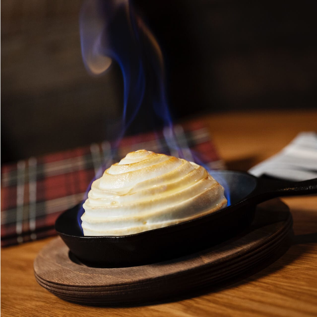 A flame rises from a baked Alaska dessert on the table at Bigfire in Universal CityWalk.