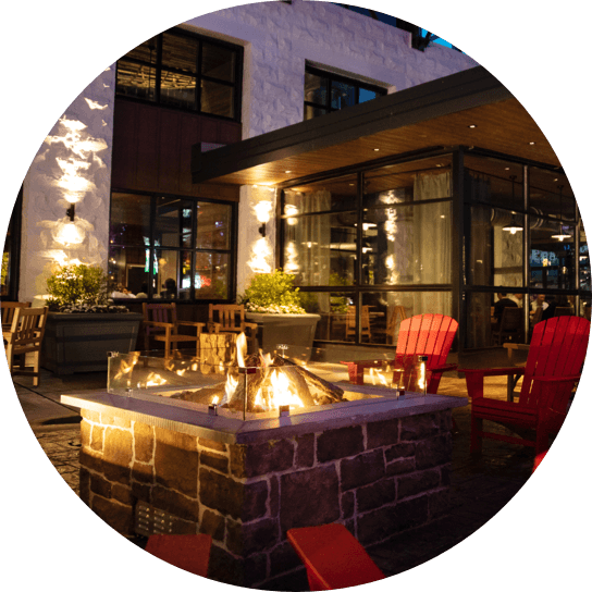 Chairs gathered around a fire pit on the patio at Bigfire