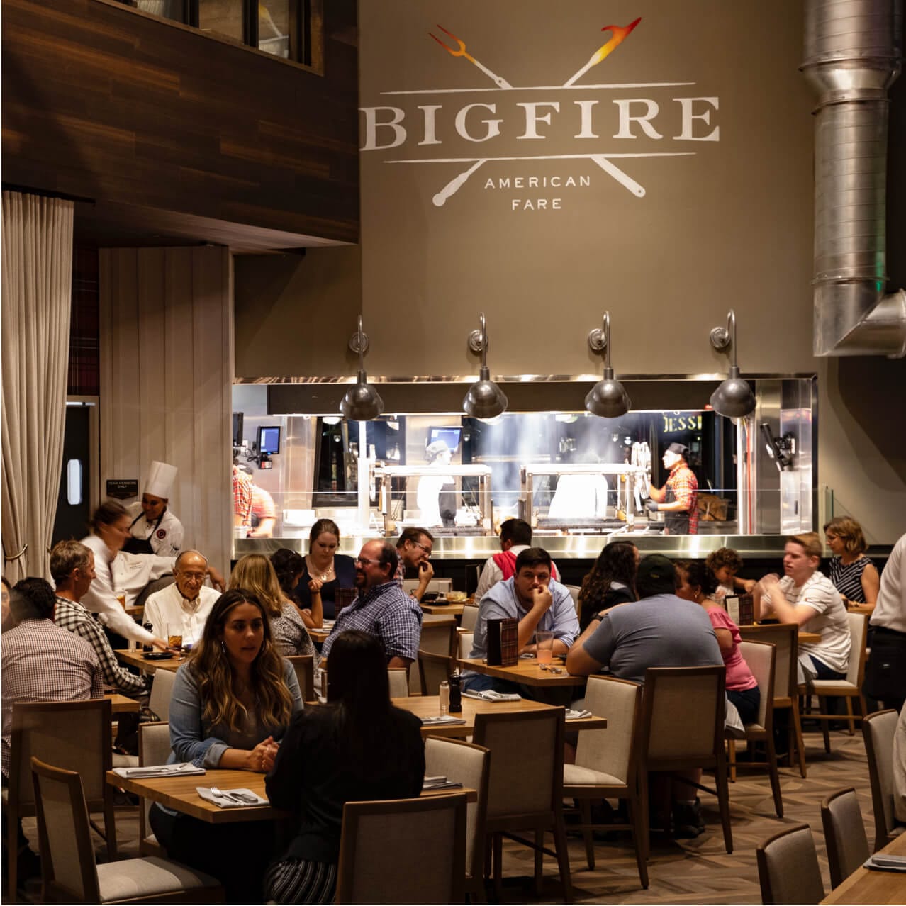 The open and modern dining room of Bigfire restaurant at Universal CityWalk is filled with diners
