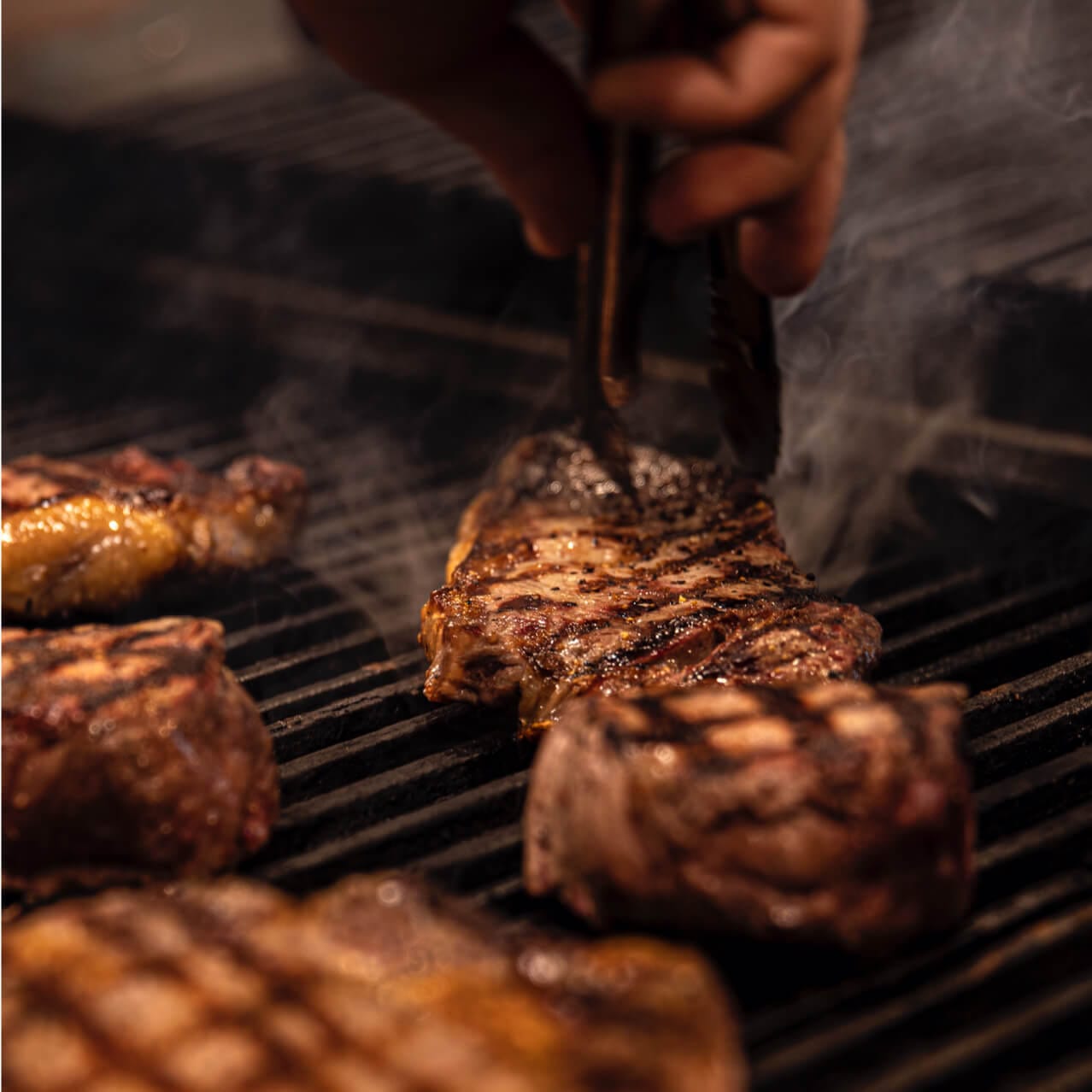 Steaks cooking on an open flame grill at Bigfire in Universal CityWalk.