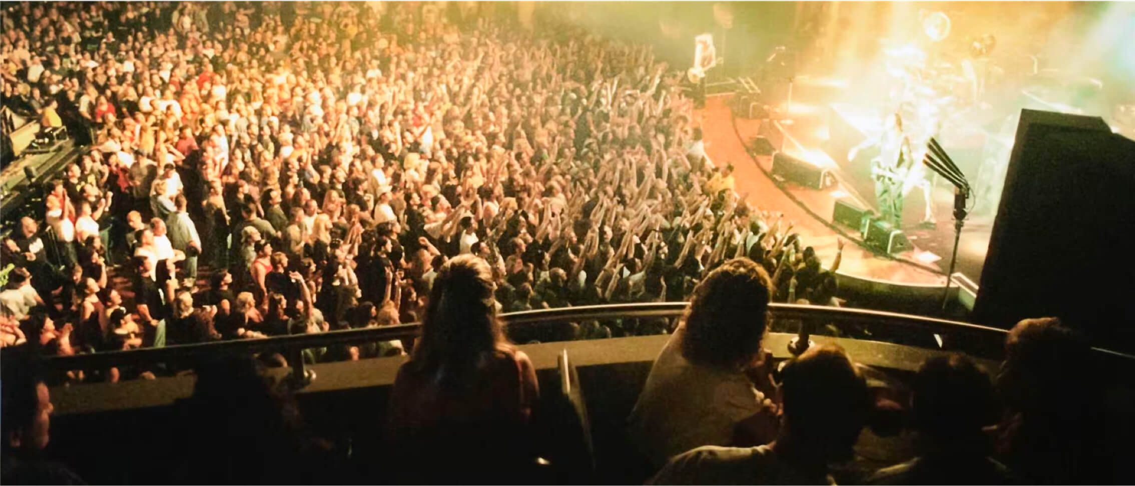 Looking down from the balcony seats inside Hard Rock Live onto the crowd below viewing a brightly lit concert.