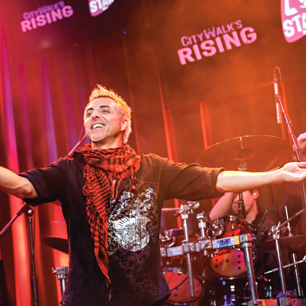 A singer stands on stage inside CityWalk's Rising Star at Universal Orlando in front of a live band.