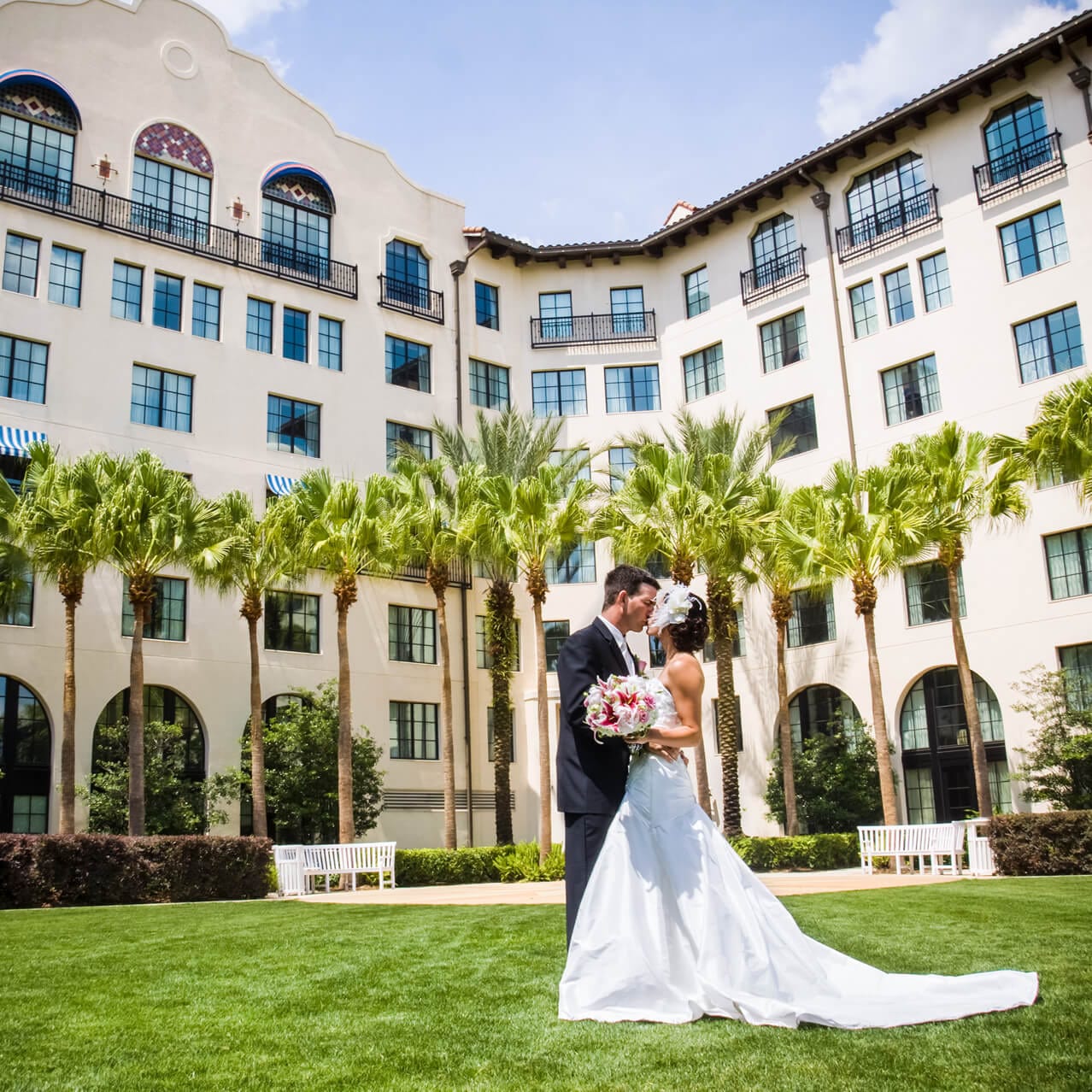 A bride and groom kiss on the lush green lawn at Hard Rock Hotel in Universal Orlando.