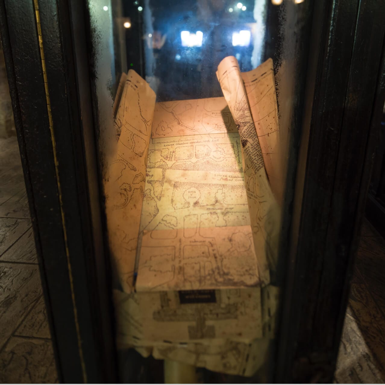 The Marauder's Map sits in a display case at Filch's Emporium of Confiscated Goods inside the Hogsmeade area of Universal's Islands of Adventure Orlando.