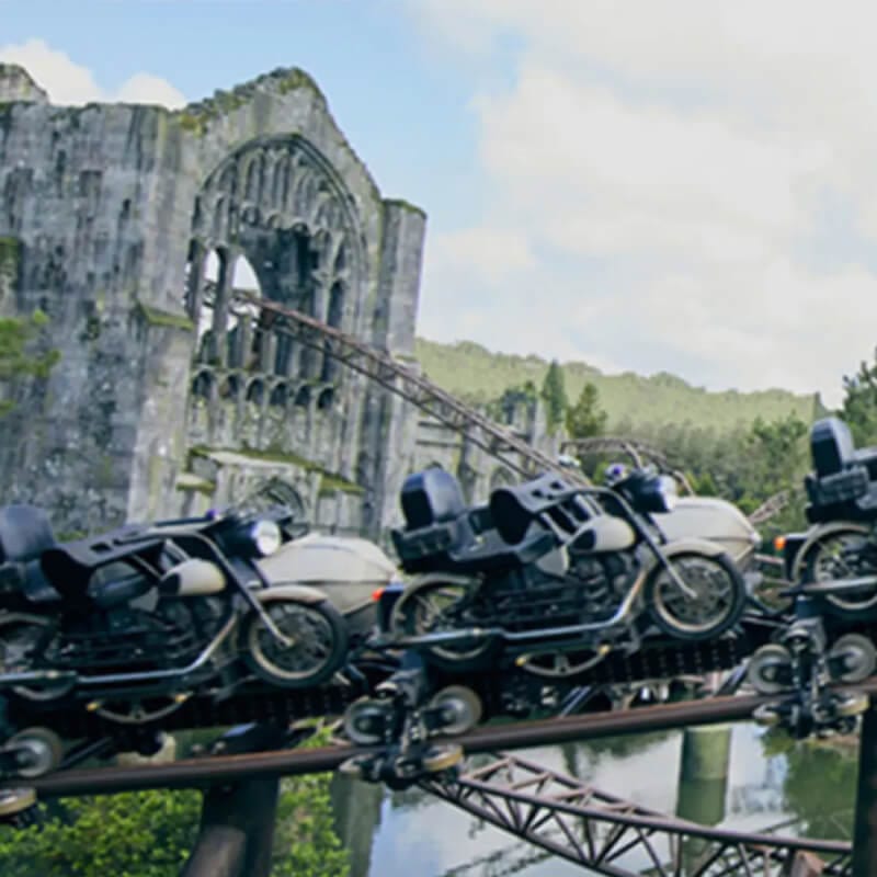 Hagrid's Magical Creatures Motorbike Adventure™ flies by the ride’s stone arch in the background.