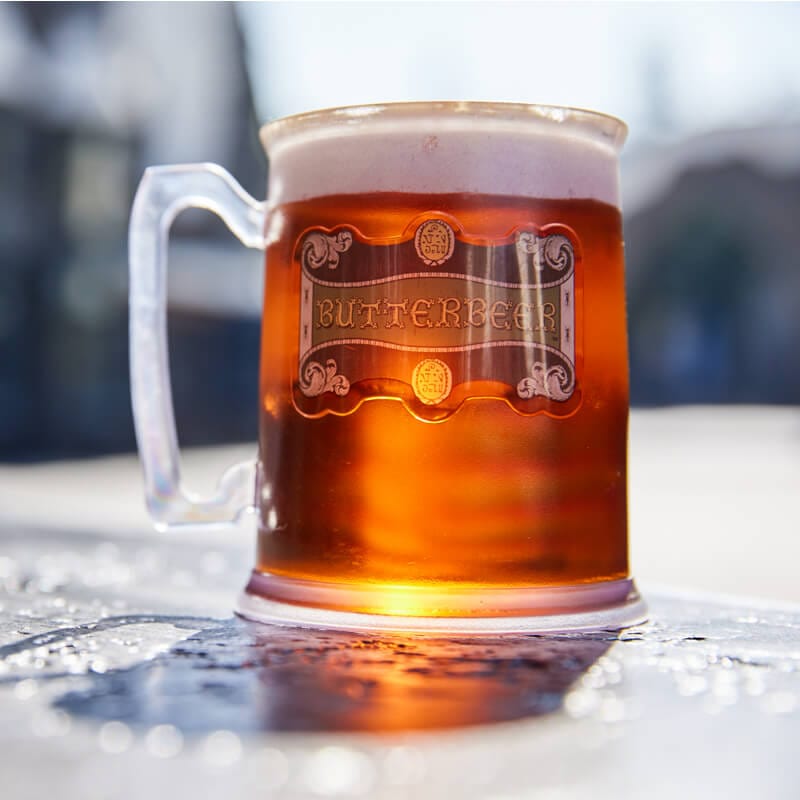 A souvenir cup filled with Butterbeer drink.