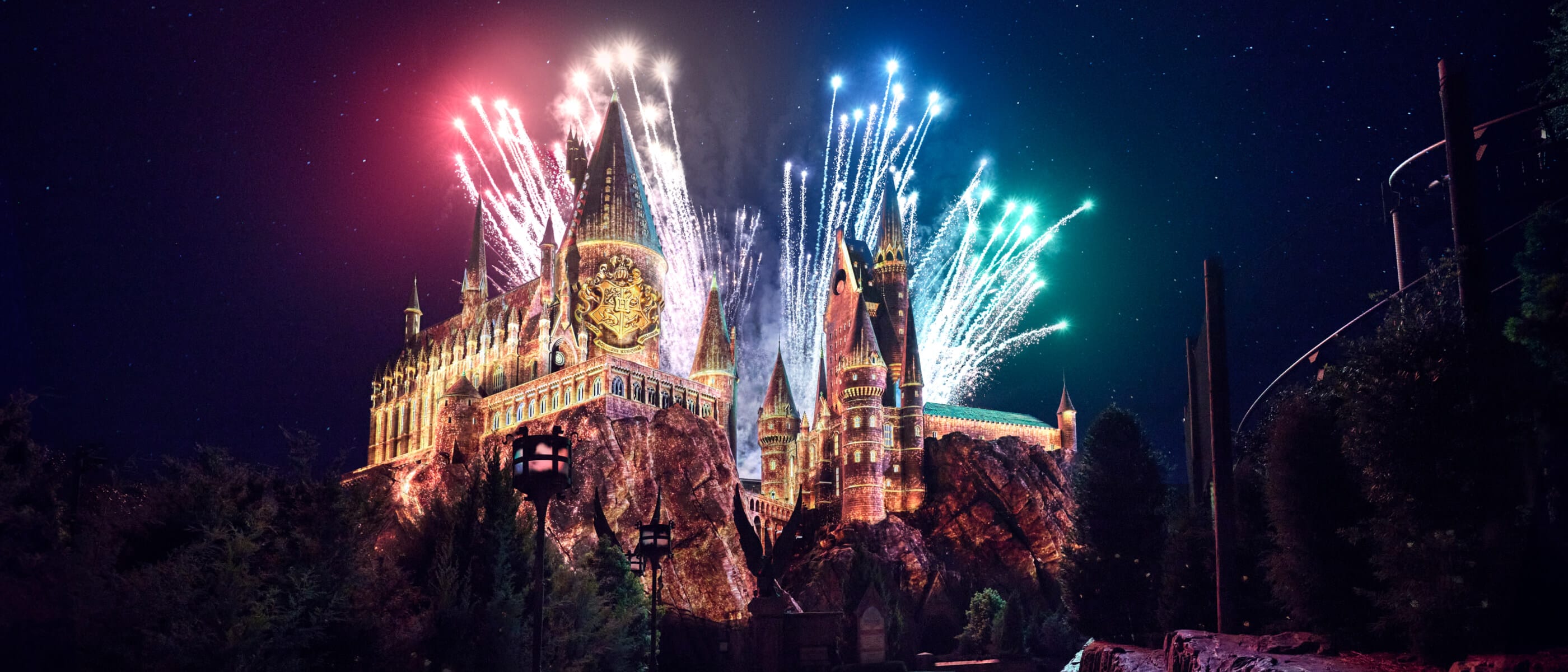 Colourful lights on display against Hogwarts™ at The Wizarding World of Harry Potter™.
