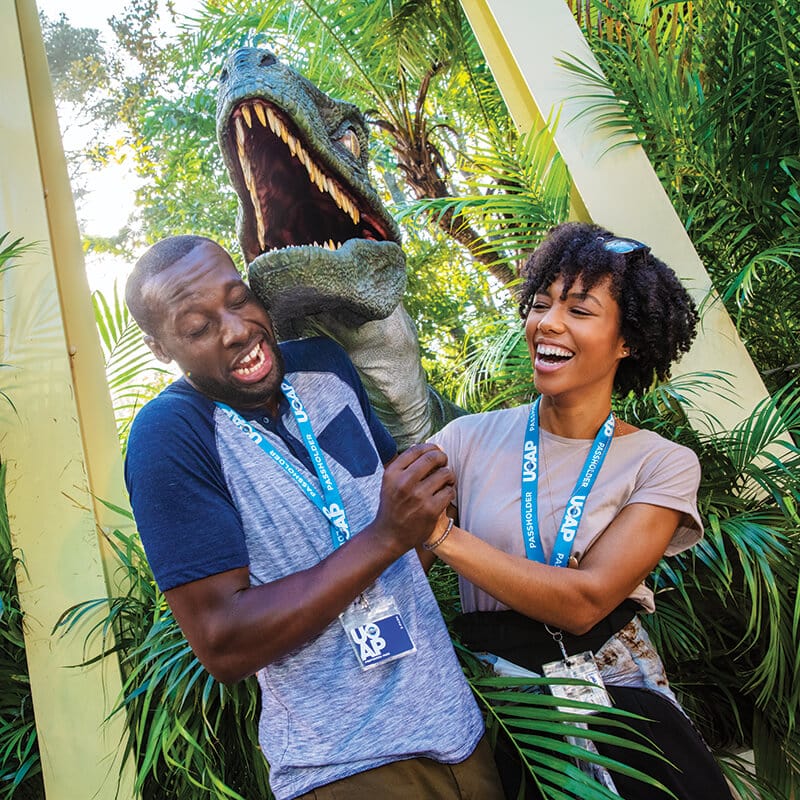 A Passholder couple reacts with fear and laughter at an encounter with Blue, the raptor.