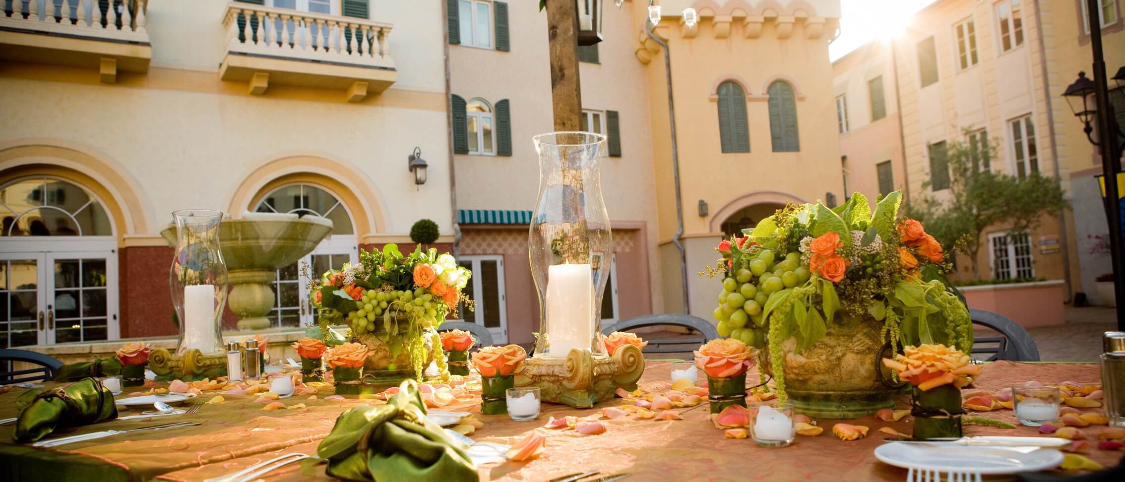 A table with floral centrepieces and candles set for a wedding reception at Loews Portofino Bay Hotel at Universal Orlando.