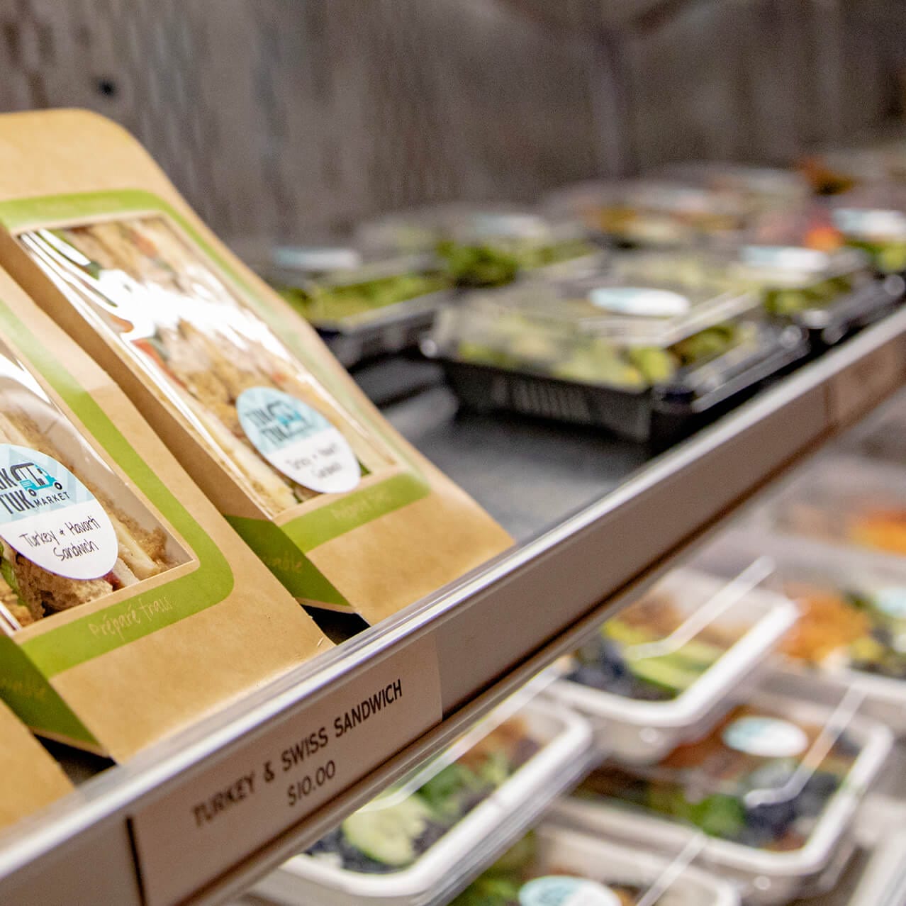 Tuk Tuk market display cooler with pre-packaged sandwiches and salads.