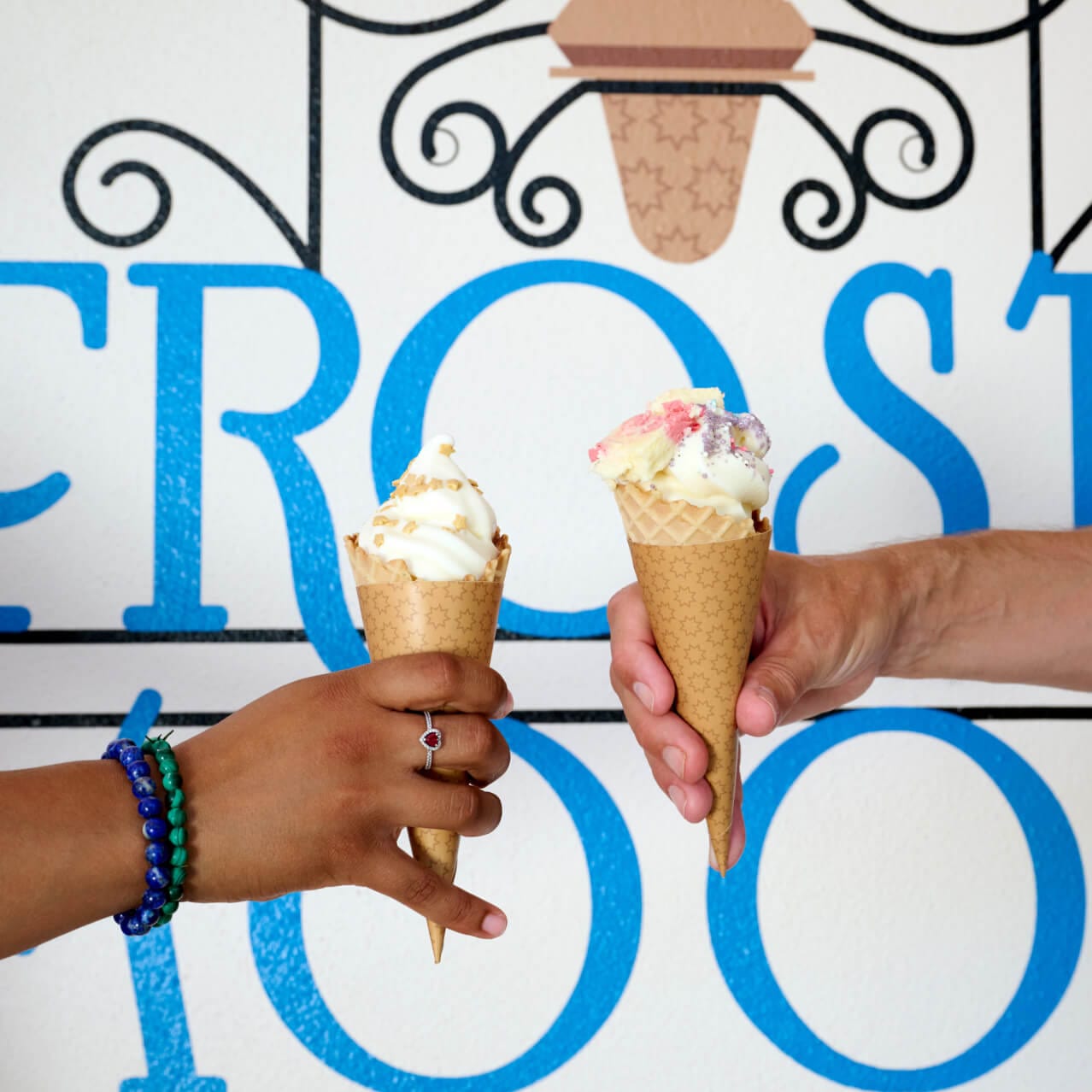 Friends hold their soft serve ice cream cones from Frosty Moon up for a photo.