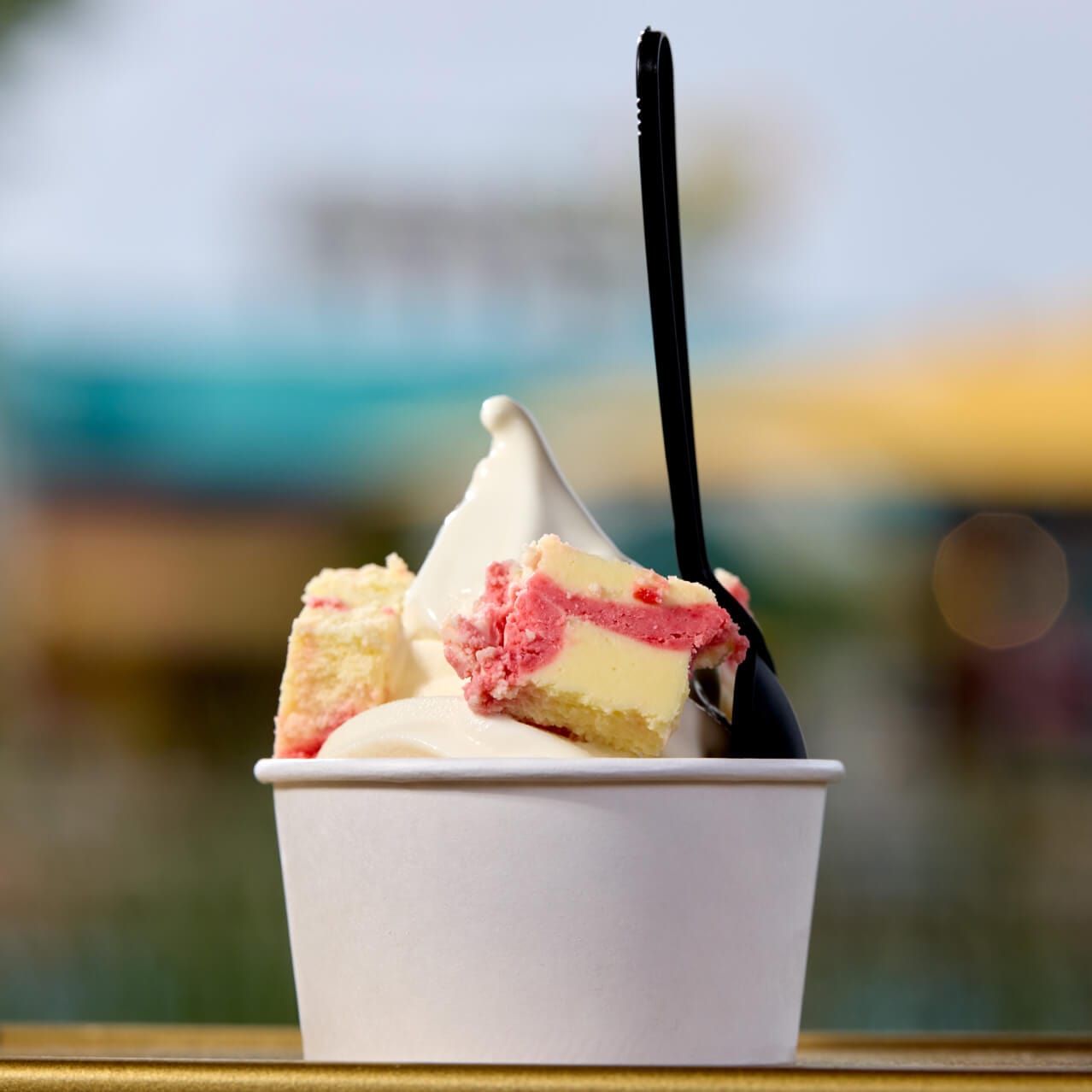 A soft serve ice cream cup with strawberry cheesecake bites from Frosty Moon, in Celestial Park.