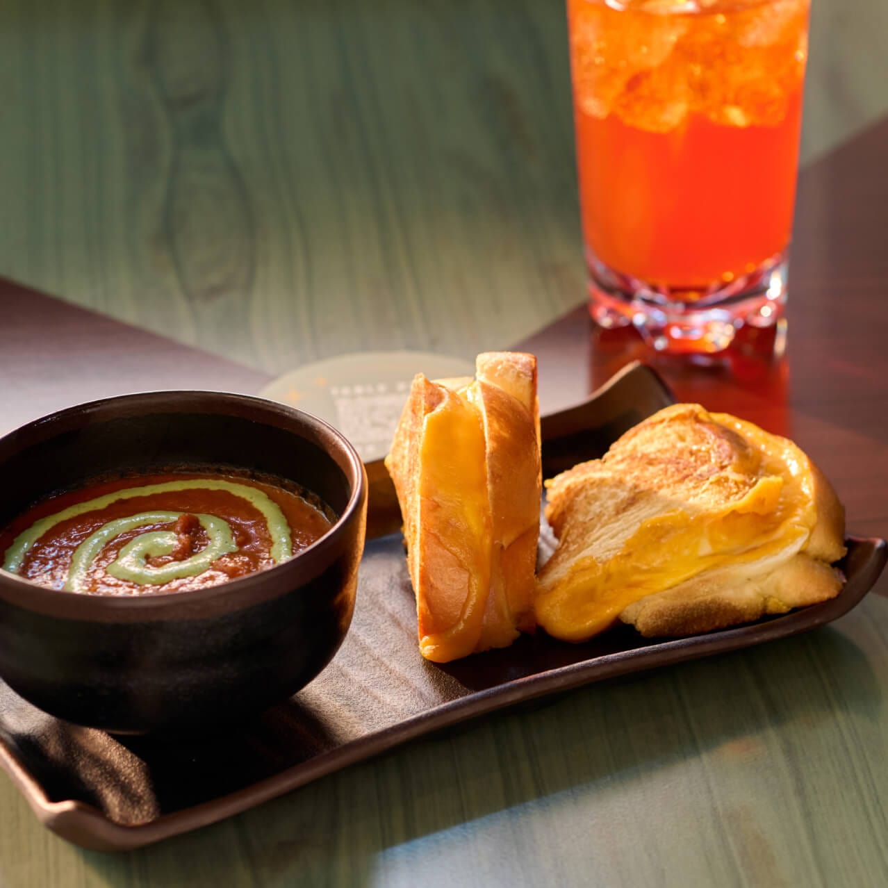 Entrée of Grilled Fourmaggio with sharp cheddar, smoked cheddar, mozzarella, American cheese served with a cup of tomato bisque, served at Meteor Astropub.