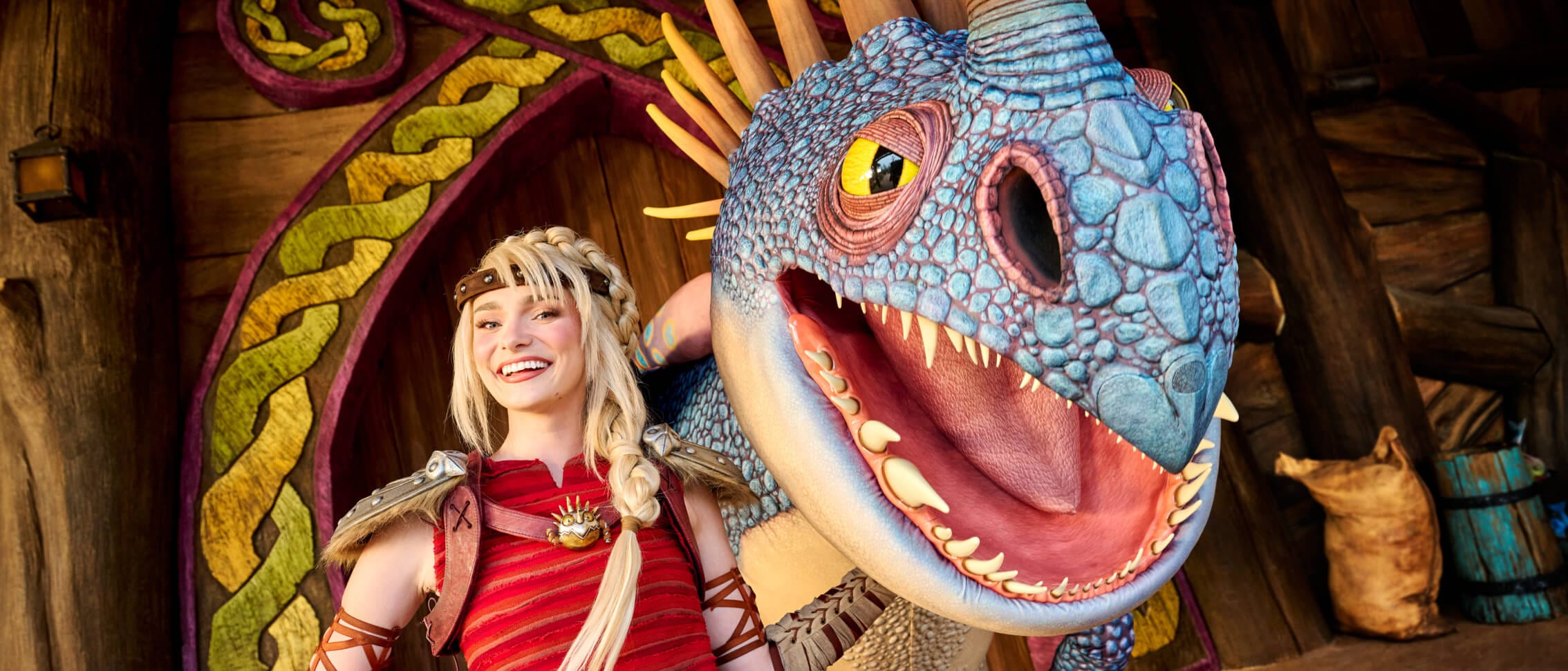 Astrid smiles next to Stormfly for a Character Meet & Greet at How to Train Your Dragon - Isle of Berk.