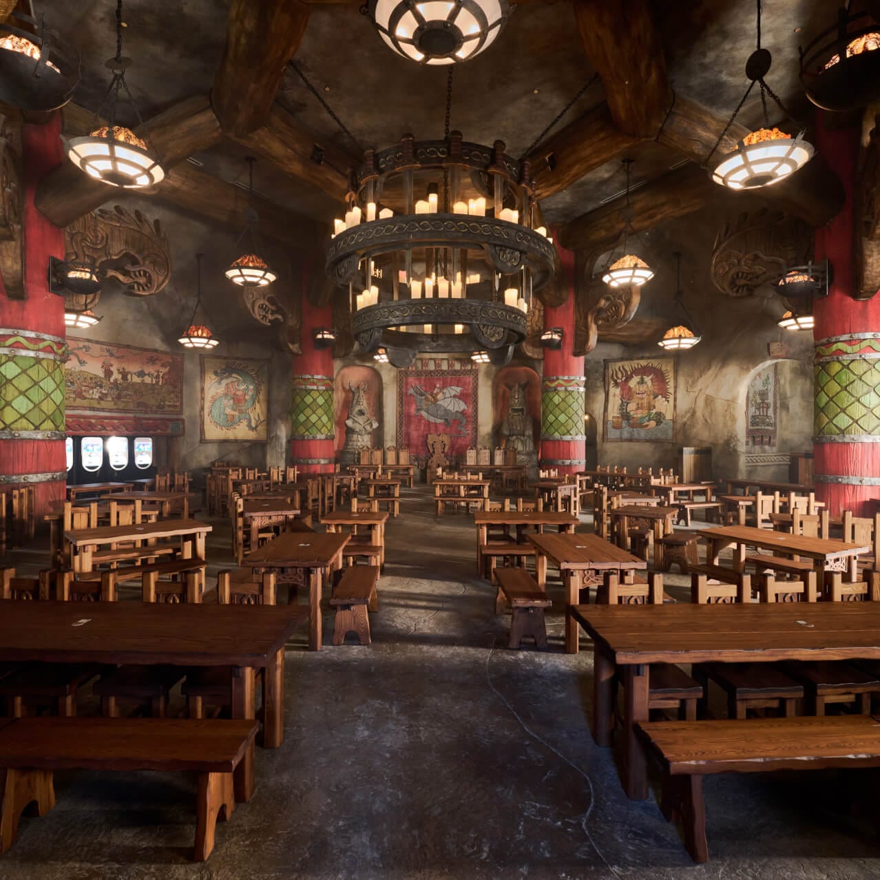 Mead Hall's grand chamber filled with tables, chairs and dragon-themed tapestries along the walls.