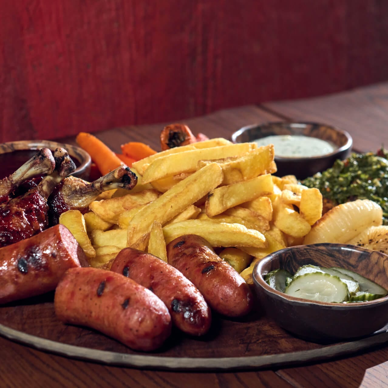 Thawfest Platter with chicken drumsticks, grilled salmon and sausage, fries and side sauces, available at Mead Hall.