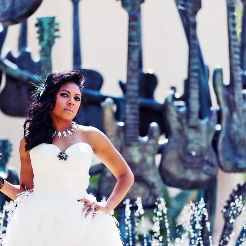 A bride posing by the guitar fountain in front of the Hard Rock Hotel at Universal Orlando.