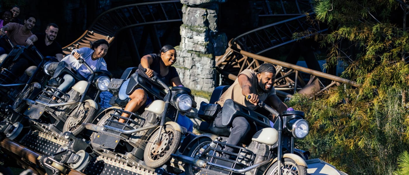 People smiling while soaring around on Hagrid's Motorbike Adventure.