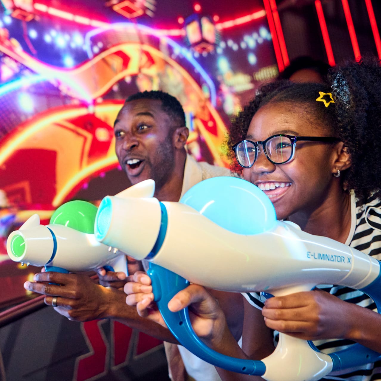 A father and daughter playing Illumination's Villain-Con Minion Blast at Universal Studios Florida.