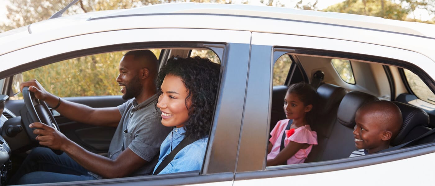 A family takes a drive with the windows down.