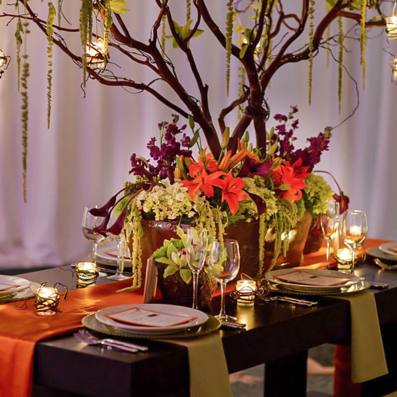 A reception table with beautiful plate settings and an elaborate floral centrepiece sets the tone for a beautiful island inspired wedding at Loews Royal Pacific Resort at Universal Orlando.