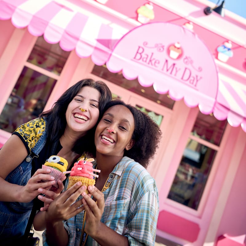 Two girls pose with their custom cupcakes inside the Illumination's Bake My Day bakery located at Universal Studios Florida.
