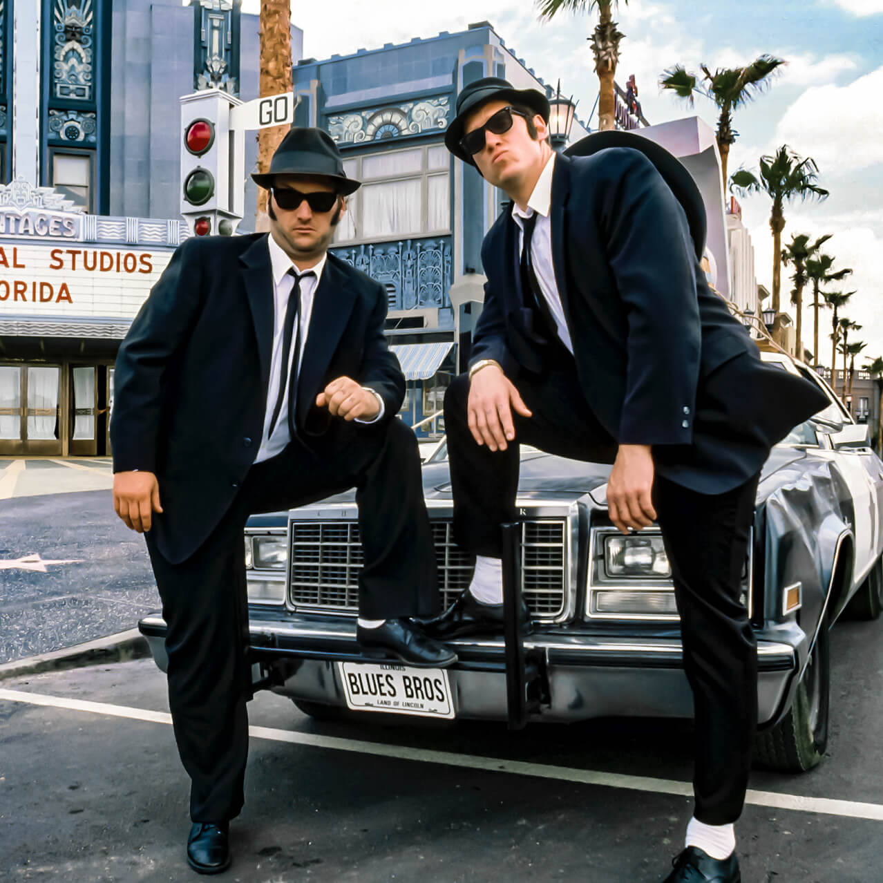Jake and Elwood from The Blues Brothers Show pose in front of the Bluesmobile at Universal Studios Orlando.