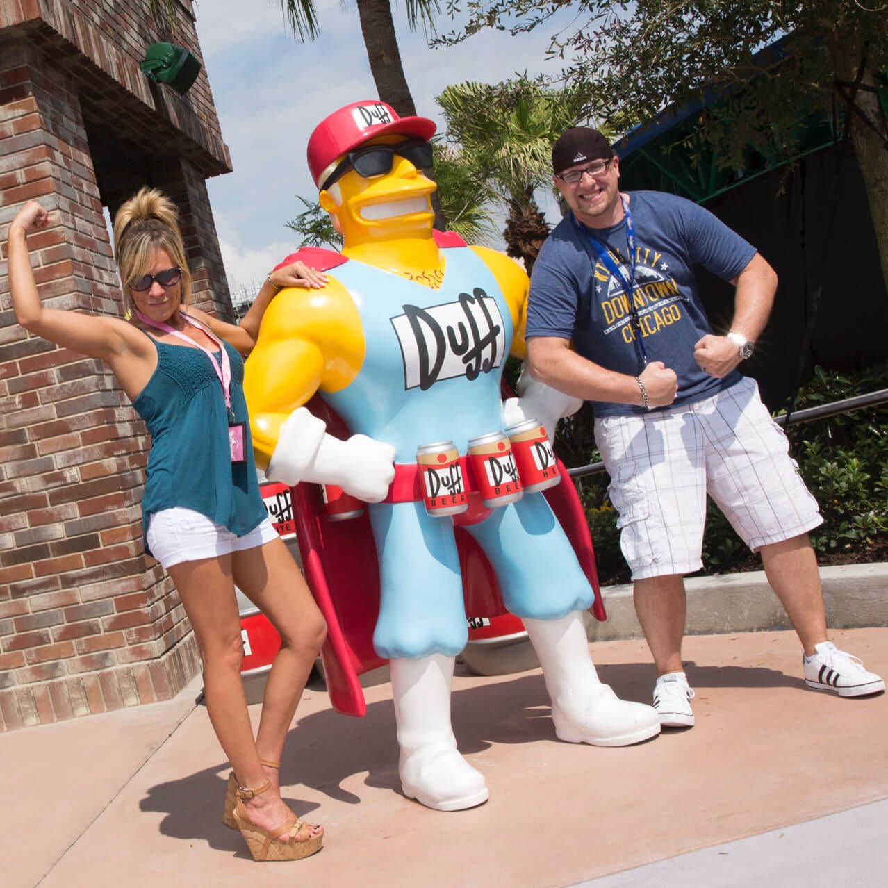 Universal Orlando theme park guests posing with Duffman outside Duff Brewery in the Simpsons themed Springfield area.