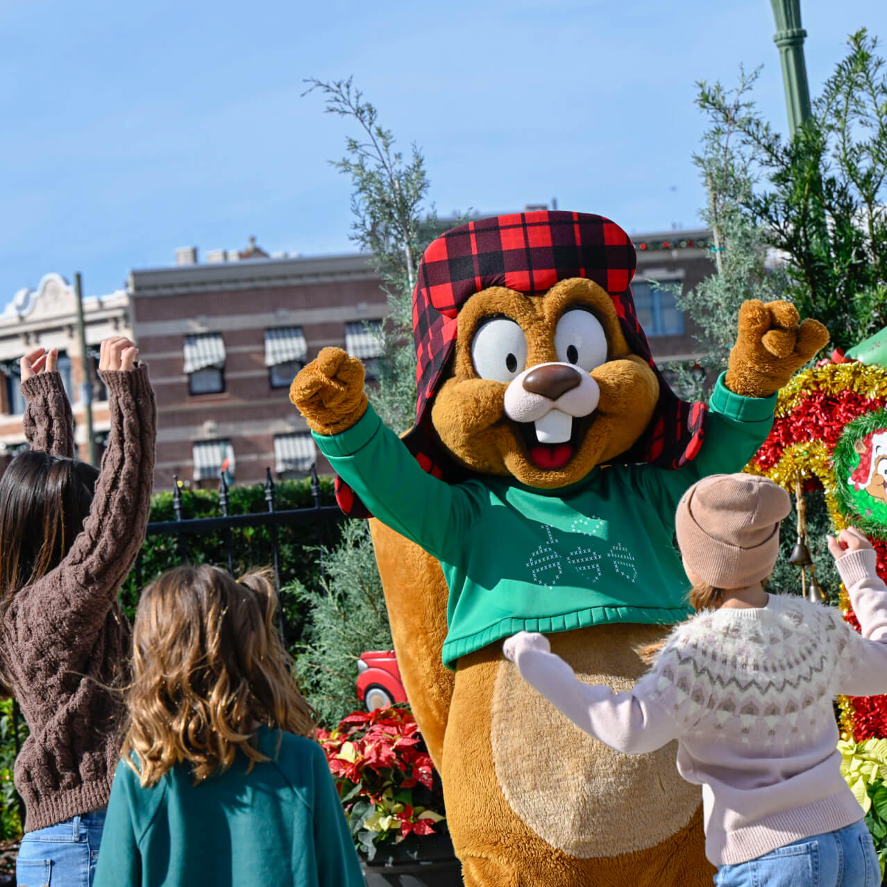 Kids dance and cheer on Earl the Squirrel alongside a festive tree at Universal Studios Florida.