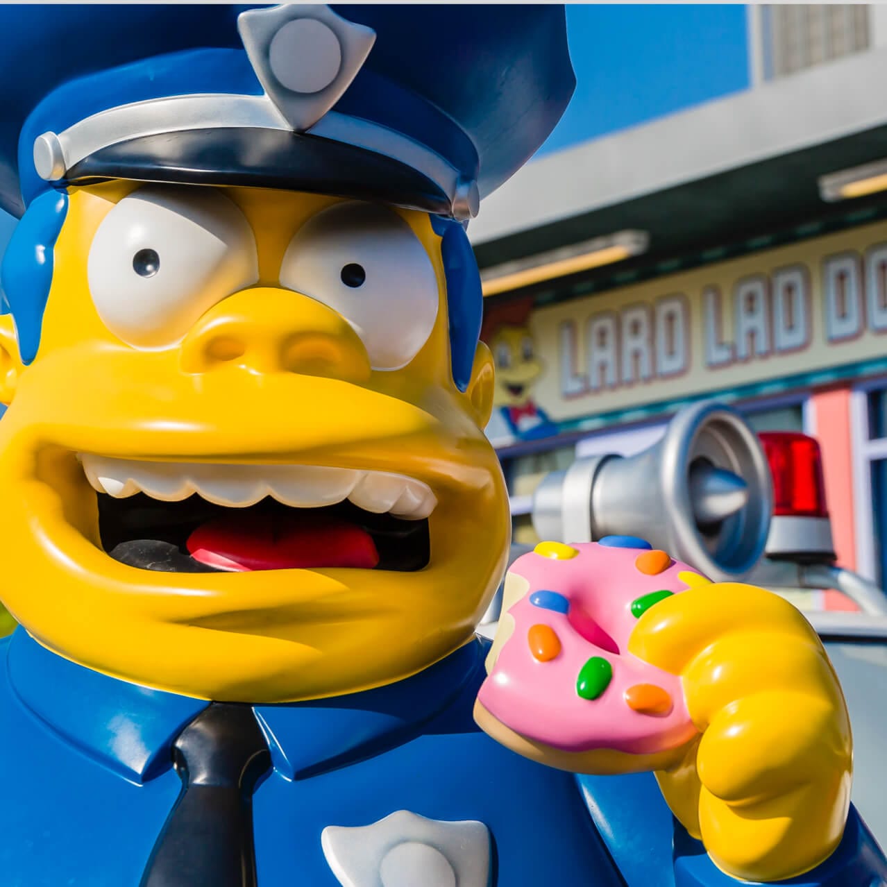 A statue of the Simpsons character Chief Wiggum stands outside the Lard Lad Donut shop in the Springfield section of Universal Studios Orlando.