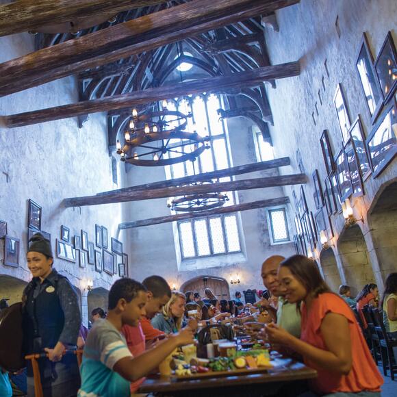 People enjoying traditional British food in the Leaky Cauldron restaurant in The Wizarding World of Harry Potter Diagon Alley at Universal Studios Orlando.