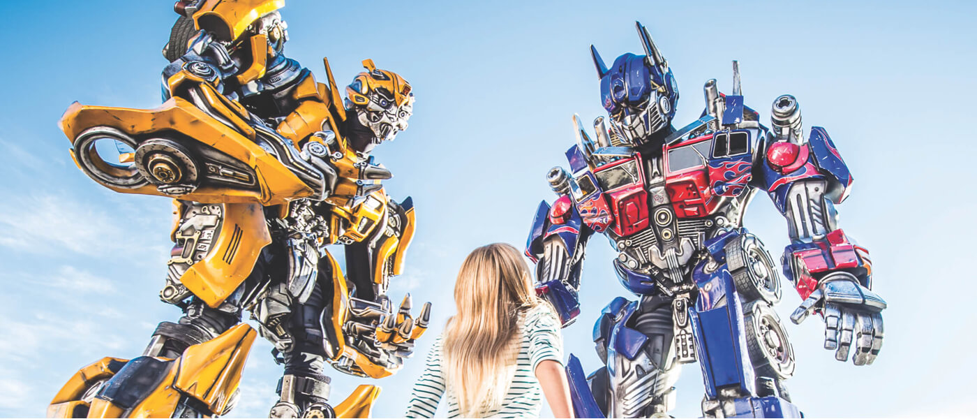 A young girl smiles up as she meets The Transformers Autobots, Bumblebee and Optimus Prime at Universal Studios Florida.