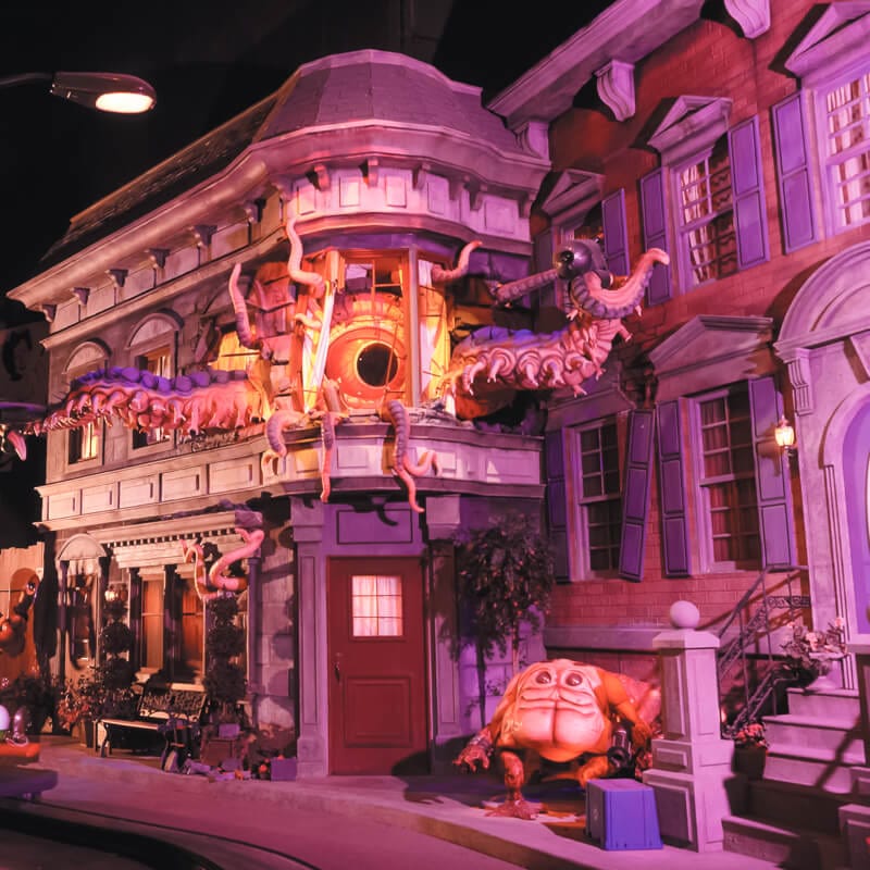 An extraterrestrial creature breaks through the windows of a building on Men in Black Alien Attack at Universal Studios Orlando.