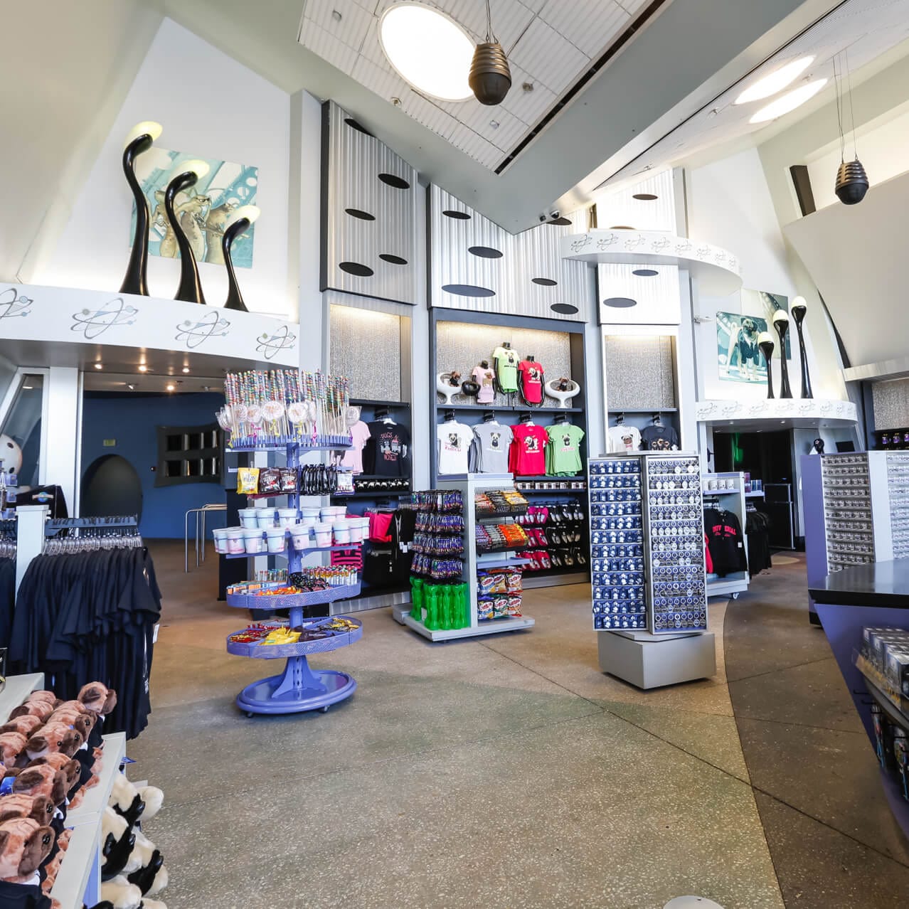 The inside of MIB Gear Shop, a modern gift shop with sleek lines at Universal Studios Orlando where you can find a collection of futuristic gifts and more.