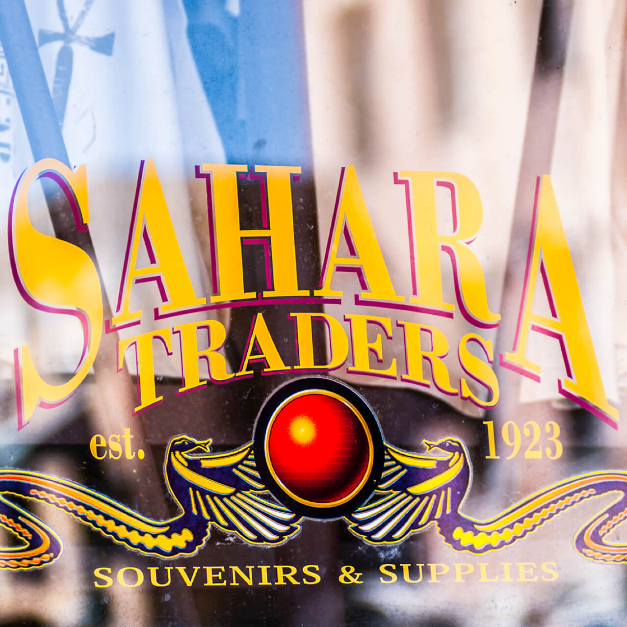 The window of Sahara Traders gift shop at Universal Studios Orlando, featuring the words 'Sahara Traders, established 1923, Souvenirs and Supplies' along with an Egypt-inspired emblem.